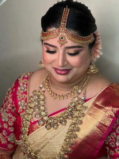 A soft, elegant pose showing the details of the eye makeup and how it complements the intricate matha patti. This is a classic Brahmin wedding look.