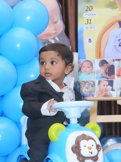 The little 'Boss Baby' Rajveer posing for a photo at his first birthday party. Themed outfits for the birthday boy or girl can complete the look of the celebration.