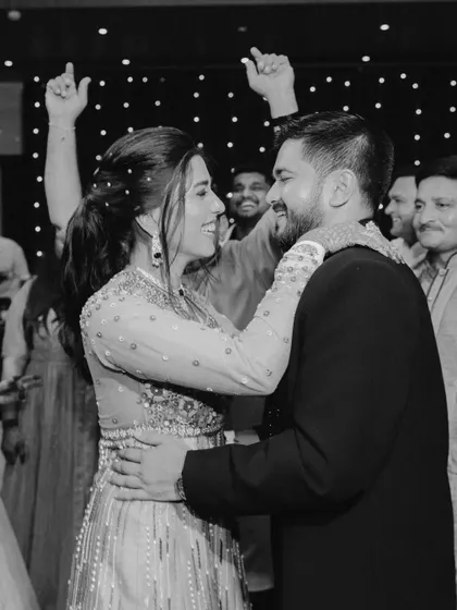 A black and white shot of the couple dancing, surrounded by their cheering friends and family. It's a timeless image of celebration and shared joy.