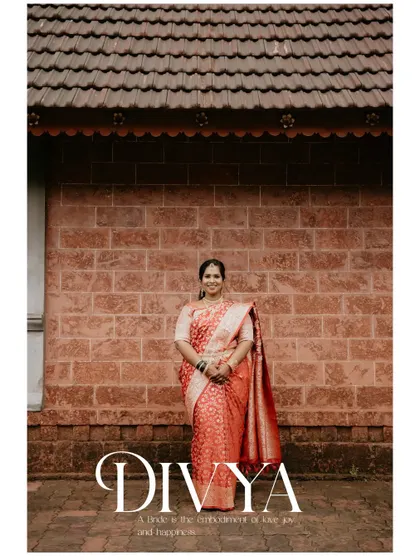 A full-length portrait of the bride, Divya, standing gracefully against a traditional brick building. The image is a beautiful blend of elegance and simplicity.