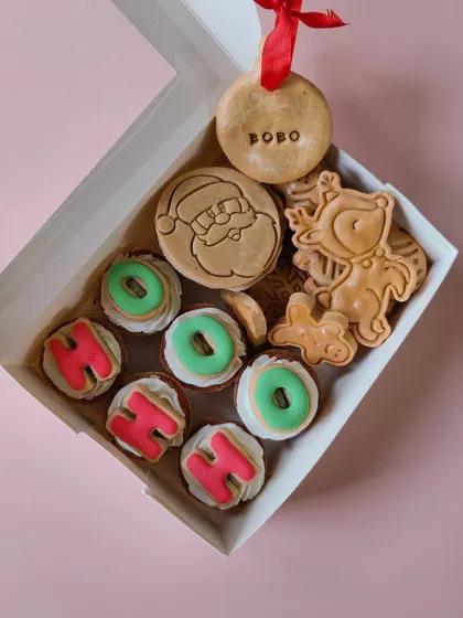 The 'Ho-Ho-Ho' Box is always a hit! It features festive mini cupcakes, Santa and reindeer shaped cookies, and a personalized bauble ornament with your dog's name.