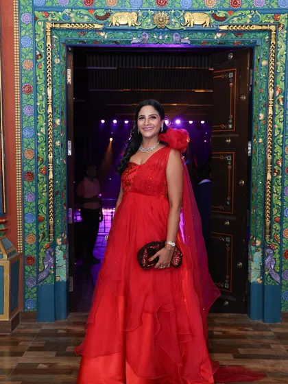 A full-length shot of Payal's stunning one-shoulder red organza gown, designed to make a statement.