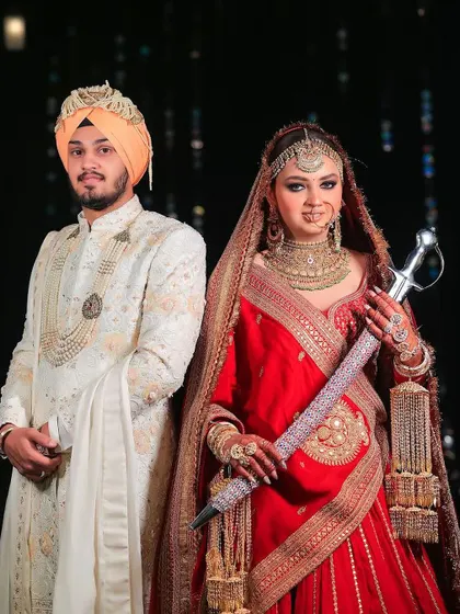 A powerful portrait of a Sikh bride and groom. The bride holds the kirpan, a symbol of strength and tradition, creating a striking and meaningful image.