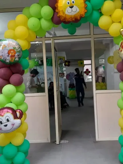 The entrance to the jungle party, featuring a balloon arch decorated with monkey, lion, giraffe, and cow foil balloons to welcome the little explorers.