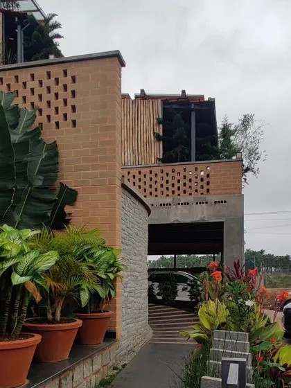 The Sunyata Hotel, where the architecture is designed to merge with the landscape. Here, brick jali walls and lush planters define the entrance.