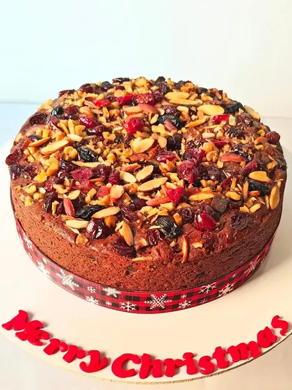 My traditional Christmas plum cake is a labor of love. It's incredibly rich and dense, packed with rum-soaked fruits and topped with a generous layer of toasted almonds and dried berries for a festive finish.