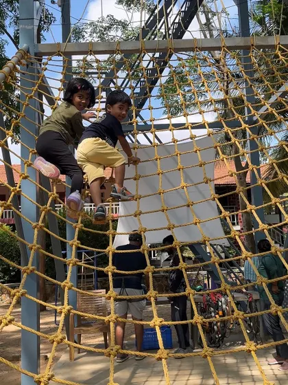 Little adventurers climbing high on the cargo net. This is a great activity for kids to burn off energy, improve their climbing skills, and play together in a safe and supervised environment.