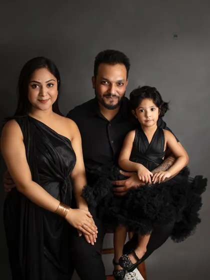A classic family portrait with a timeless feel. Coordinated outfits against a dark, elegant backdrop create a sophisticated look that you will treasure forever as a family heirloom.