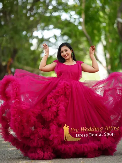 A happy, celebratory shot in the magenta ruffled gown, with the skirt spread wide to show its full volume.