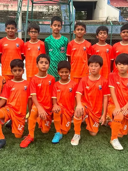 The U11 team posing for a photo before their match on a cloudy day.