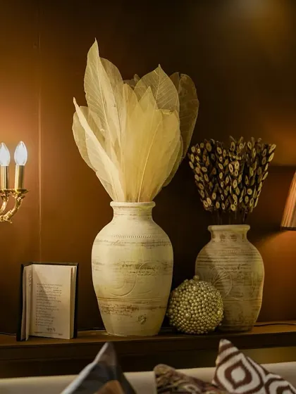 A corner detail from the lounge area, featuring a vintage candelabra, textured vases, and dried arrangements that create a sophisticated, library-like feel.