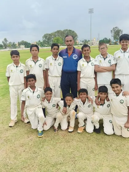A U-12 team poses with their coach.