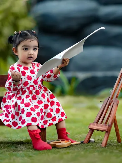 A little artist contemplating her next masterpiece. The outdoor setting adds a beautiful, natural light to the scene.