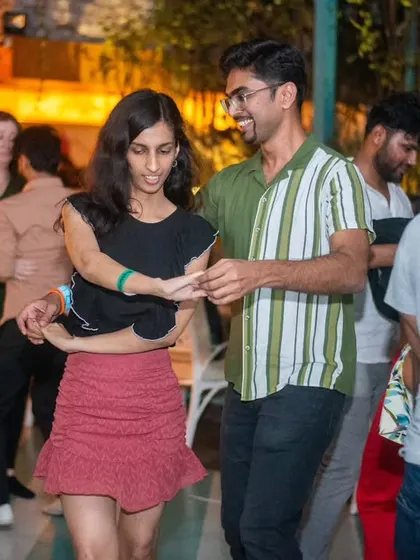 A stylish couple moving together smoothly. The green and white striped shirt adds a pop of color.