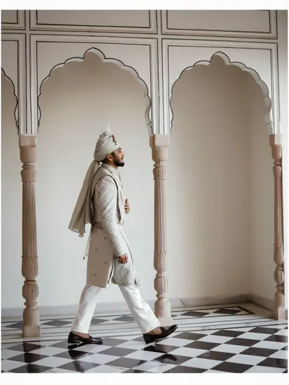The groom's solo portrait, capturing his regal attire and confident stance in a palace corridor.