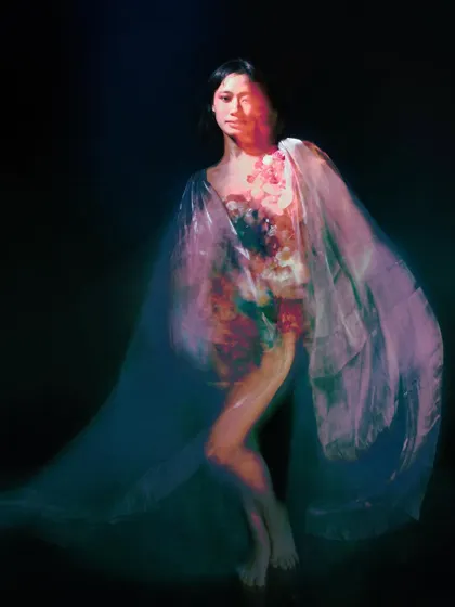 A full-body shot with significant motion blur, creating a ghostly, flowing silhouette. The movement in the image conveys the emotional turmoil and ethereal nature of the character.