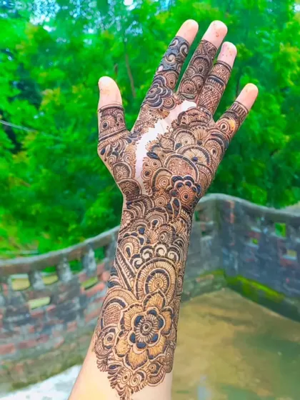 A classic full-hand design that extends up the wrist, featuring a mix of floral, paisley, and geometric elements.
