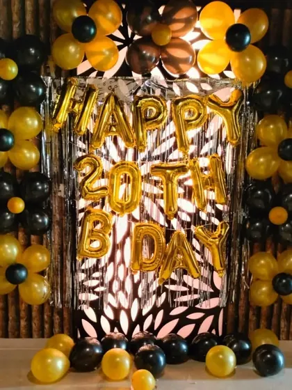 Another angle of the stylish 20th birthday setup. The combination of black and yellow balloons arranged like flowers against the shimmer curtain creates a very graphic and memorable backdrop.