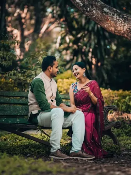 A candid moment of laughter shared on a park bench. This pre-wedding shot captures the easy comfort and happiness between the couple.