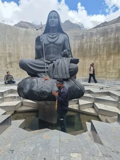 **Adi Shankaracharya Samadhi.** A devotee paying respects at the samadhi of Adi Shankaracharya, located just behind the Kedarnath temple.