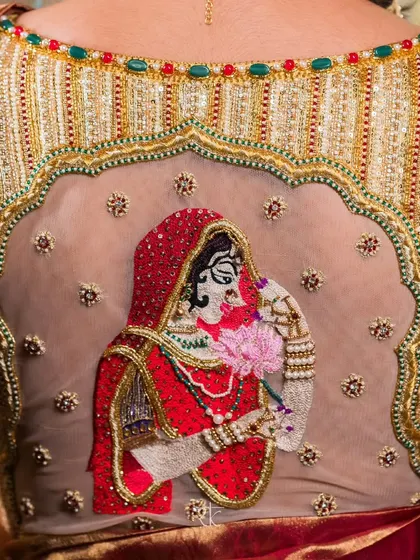 This bridal blouse is a canvas where stories are told in thread. The intricately embroidered depiction of a bride, set against a sheer back, is a hallmark of the personalized artistry I bring to your most special day.