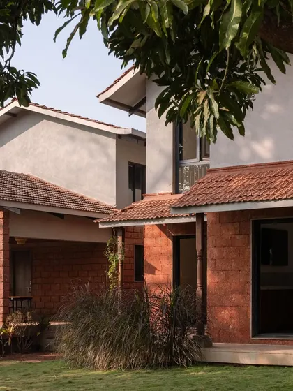 The exterior of Maison Rouge, showing the combination of pitched terracotta roofs and laterite walls, typical of Konkan architecture.