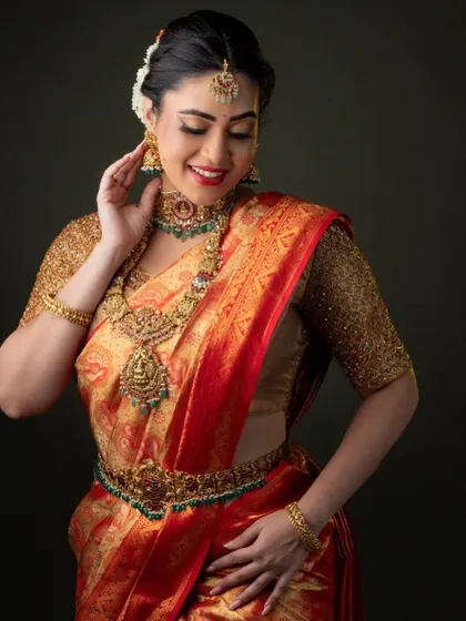 This bride looks so graceful. She is wearing a beautiful temple jewellery set that perfectly complements her red and gold Kanjeevaram saree.