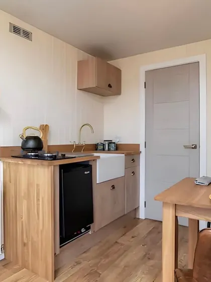 A compact kitchenette designed for one of our smaller container homes. It includes all the essentials like a sink, cooktop, and mini-fridge, proving you don't need a lot of space to have a functional kitchen.