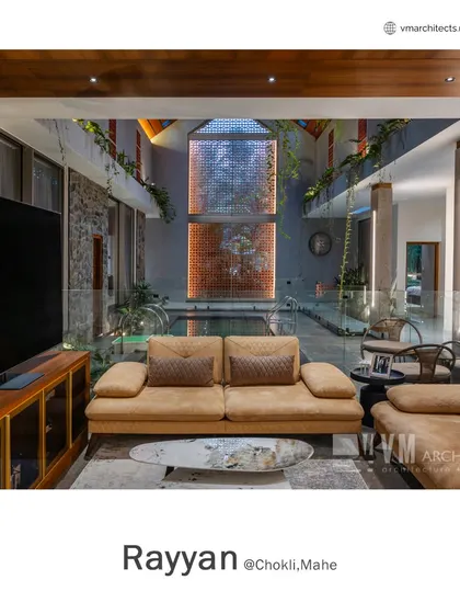 The living area at Rayyan overlooks the central double-height space containing the swimming pool, with hanging plants and a terracotta jali wall enhancing the connection to nature.