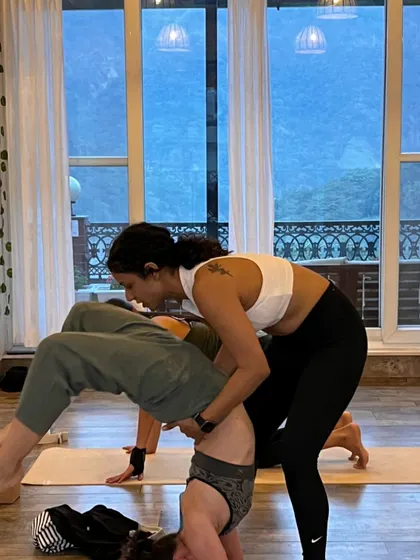 Happiness is helping a student find their balance. Here I am assisting with a supported headstand, a moment of trust and teamwork.