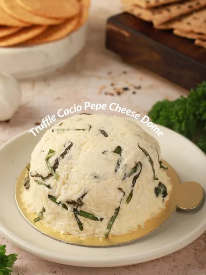 A closer look at our Truffle Cacio Pepe Cheese Dome. You can see the fresh herbs and cracked pepper blended into the creamy, truffle-infused cheese, perfect with simple crackers.