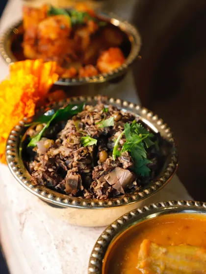 A close-up of the Banana Blossom Thoran. You can see the intricate texture of the finely chopped blossom mixed with lentils and spices. It's a special dish, available exclusively on preorder.