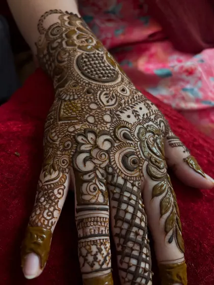 A close up of a detailed design on the palm. The mix of floral, paisley, and geometric patterns creates a rich and textured look.