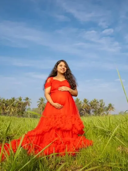 A beautiful portrait of a mom-to-be in a vibrant red ruffle gown, perfect for capturing the joy of pregnancy.