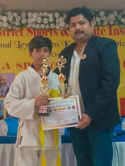 One of our yellow belt students holding two trophies after his victory at the Karwar open national level championship. A fantastic achievement in both kata and kumite.