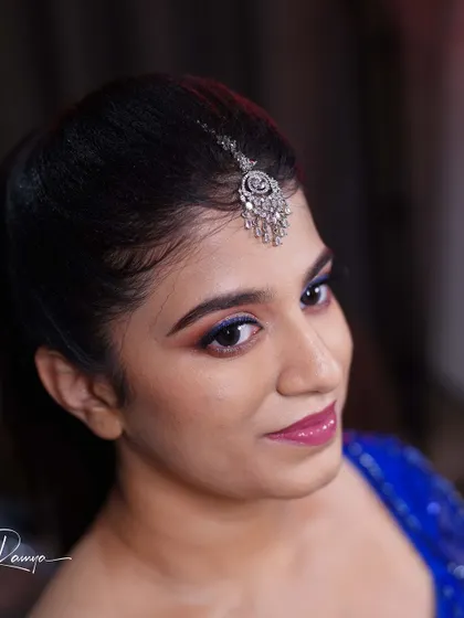 A close-up of Meghana's reception makeup. The pop of blue eyeliner adds a fun and modern twist to the shimmery pink eyeshadow, perfectly matching her royal blue dress.