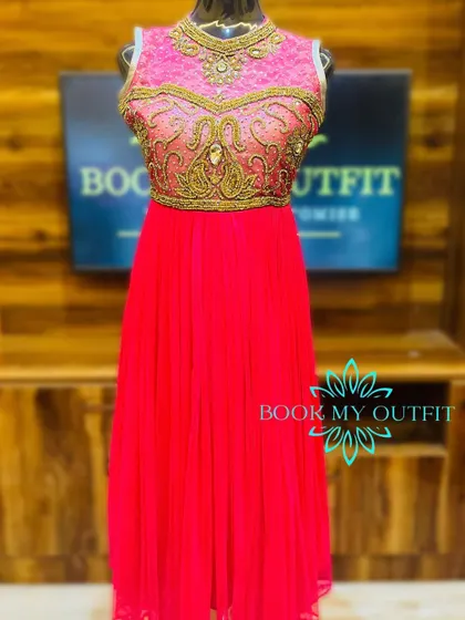 A vibrant pink long gown with a heavily embellished gold bodice. The combination of the bright color and intricate detailing makes this a show-stopping choice for any celebration.