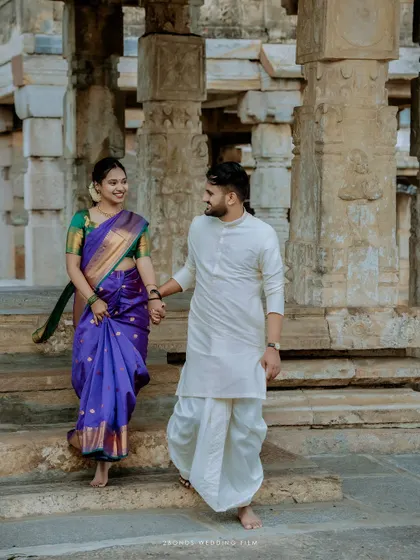 The couple walks hand-in-hand through the stone pillars of a temple, a classic shot that symbolizes the beginning of their journey together.
