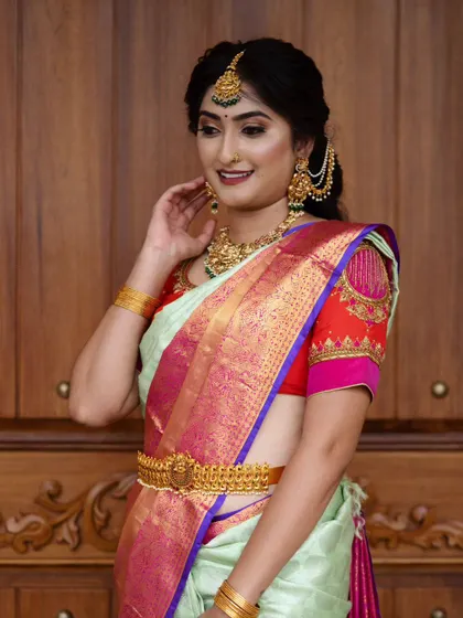 A classic South Indian festive look. The combination of a silk saree, temple jewellery, and a neat hair updo is timeless. The makeup is kept glowing and fresh to complete the style.