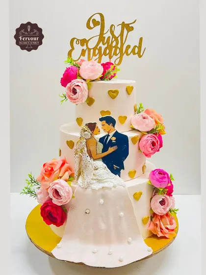 I crafted this three-tier "Just Engaged" cake to capture the romance of the occasion. It features a beautiful illustration of the couple, a flowing gown detail, and delicate floral accents, all made with my signature eggless chocolate mousse recipe.