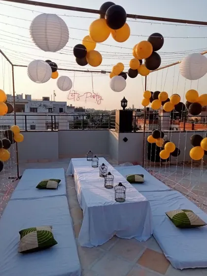 A wide shot of the terrace party setup during the day, showing how the decorations transform the open space.
