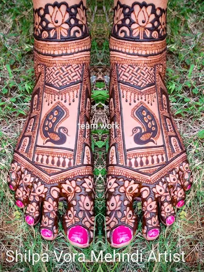 A beautiful foot design featuring peacocks within a geometric frame, with floral details on the toes. This was a team effort for a bridal party.