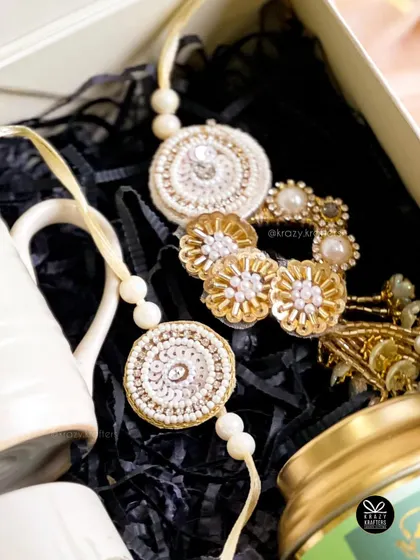 A detailed shot of the beautiful handcrafted lumba and rakhi set, the centerpiece of our couple Rakhi hampers.