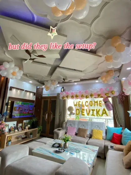 A wide-angle view of the welcome home decor for baby Devika. This shot shows how balloons were used not just for the main backdrop but also on the ceiling to fill the entire room with a festive and joyful feeling.
