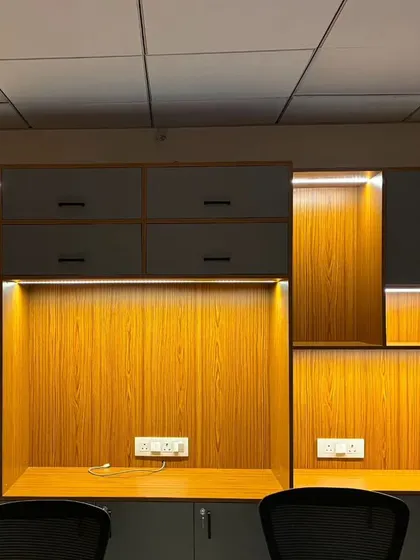 The same office workstations in "dark mode," with the warm under-cabinet lights creating a cozy and focused ambiance.