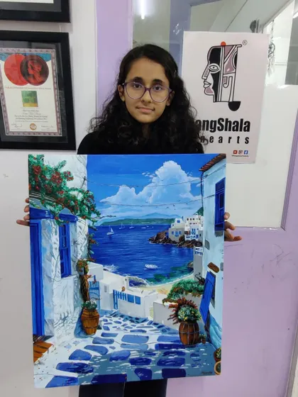 A proud student displays her finished acrylic on canvas painting of a Santorini landscape. This shows the complete journey from a blank canvas to a vibrant, portfolio-worthy artwork.