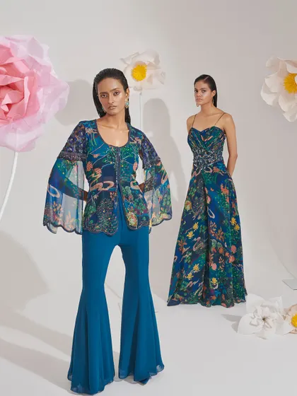 Two complementary looks in a blue floral print, one a jumpsuit with a cape and the other a gown. This is perfect for styling a bride and her sister or best friend.