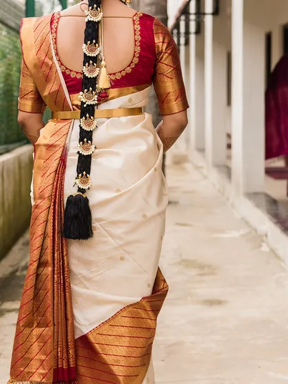 A view of the traditional bridal hairstyle. This long, thick braid is adorned with beautiful hair ornaments, known as jadanagam, completing the quintessential South Indian bridal look.