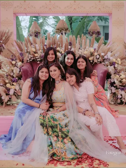 A lovely group photo of the bride with her bridesmaids on the Sangeet stage, all smiles.