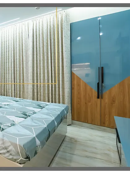 A close-up of the unique wardrobe design, combining glossy blue laminate with a diagonal wood-patterned section. It's a small detail that makes a big impact.
